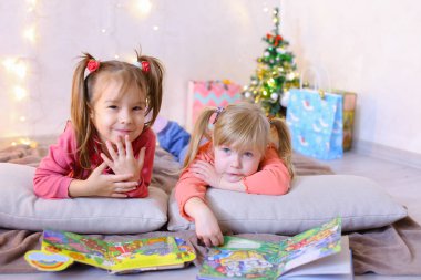 Sevimli küçük kızlar birlikte oynamak ve sohbet, yerde yatıyor ve