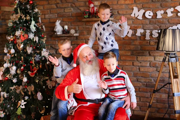 Weihnachtsmann und Geschwister schicken schöne Grüße in die Kamera — Stockfoto