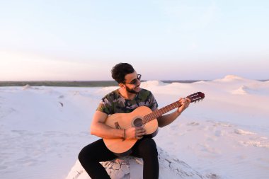 Çekici Arap adam gitar, Hill'de oturan şarkı söylüyor