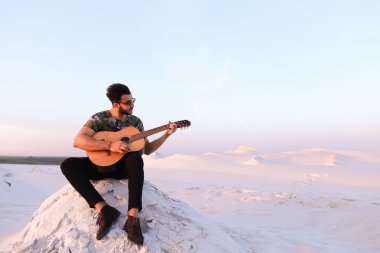 Çekici Arap adam gitar, Hill'de oturan şarkı söylüyor