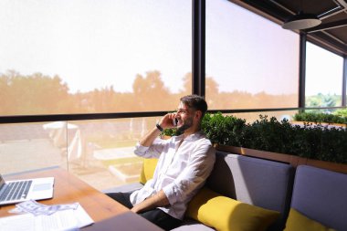 Smartphone ile konuşmak ve laptop ile çalışma emlak komisyoncusu