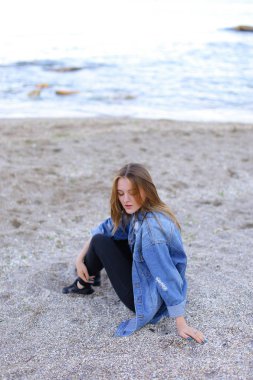 Dinlenme, deniz kenarında oturan ve b kameraya poz güzel kız