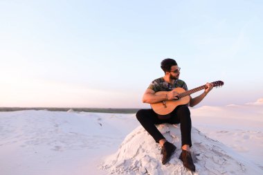 Çekici Arap adam gitar, Hill'de oturan şarkı söylüyor