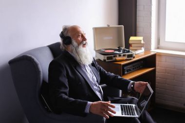 Kıdemli bilgisayarda çalışır ve kulaklık müzik hoşlanır