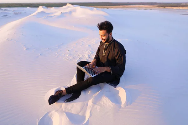 Гарний хлопець з арабських пише на Інтернет, використовуючи ноутбук і сидить — стокове фото