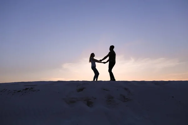 Os amantes correm em direção um ao outro e giram em uma colina arenosa no deserto — Fotografia de Stock