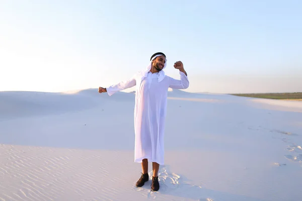 Šťastné muslimské chlap chodí přes rozlohy pouště a nesou — Stock fotografie