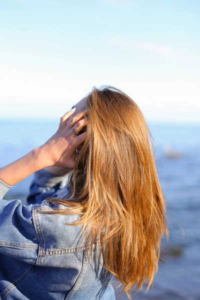 Hezká holka se zády k fotoaparátu líbí mořský vzduch, stojany na moři — Stock fotografie