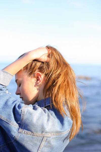 Mooi meisje met de rug naar camera genieten van de zeelucht, stands op zee — Stockfoto