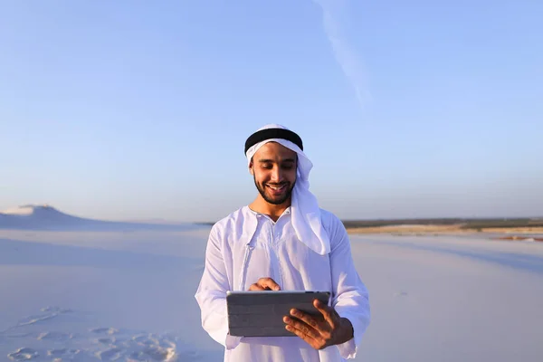 Successful Arabian businessman holds in hands and uses tablet, s — Stock Photo, Image