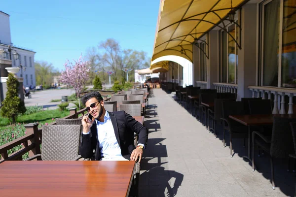 Arabian guy talking with friendby phone — Stock Photo, Image