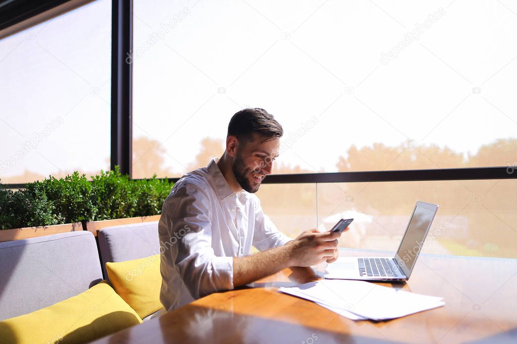 Real estate agent  talking by smartphone and working with laptop
