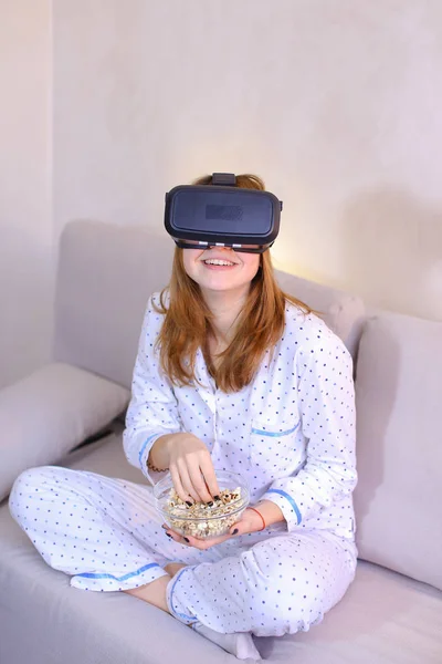 Fajna dziewczyna zegarki wideo w okulary Vr, siedząc na kanapie w brigh — Zdjęcie stockowe