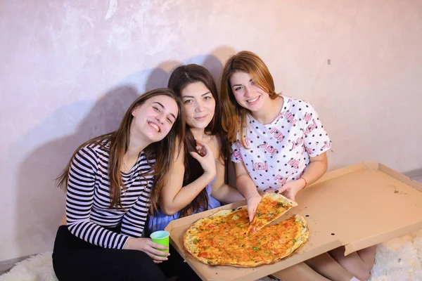 Gadis-gadis manis santai menghabiskan waktu dan menikmati pizza, duduk di lantai di brig — Stok Foto