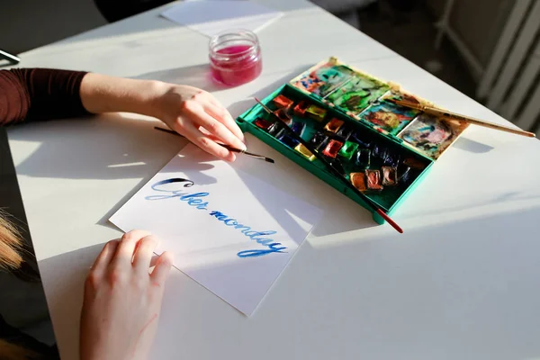 Θηλυκό καλλιγράφος δημιουργεί επιγραφή προς πώληση, χρησιμοποιώντας βούρτσες — Φωτογραφία Αρχείου
