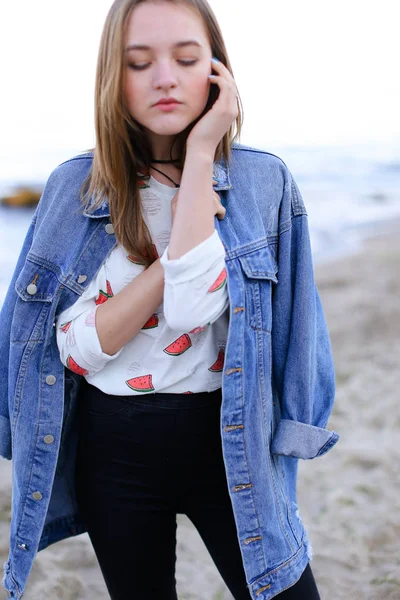 Charming woman posing on camera, standing on seashore on calm su — Stock Photo, Image