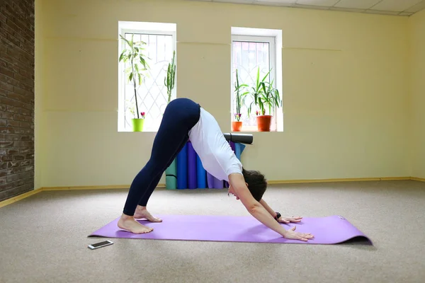 Hermosa chica haciendo ejercicios de estiramiento y asanas de yoga . — Foto de Stock