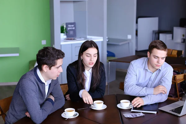 Mujer joven y los hombres modernos están descansando del bullicio del trabajo en el almuerzo — Foto de Stock