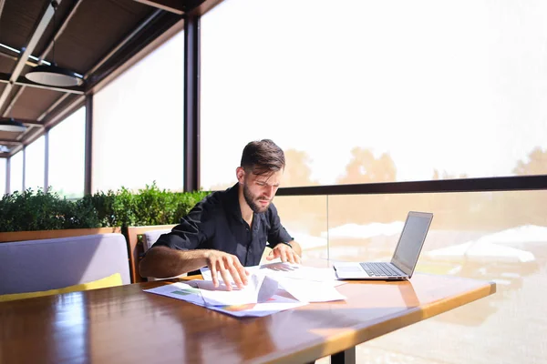 Ufficio di smistamento carte sul tavolo vicino laptop . — Foto Stock