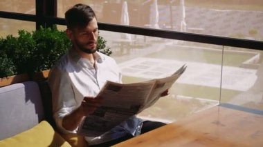 Gazete okuma ve merak yakışıklı erkek kişi.