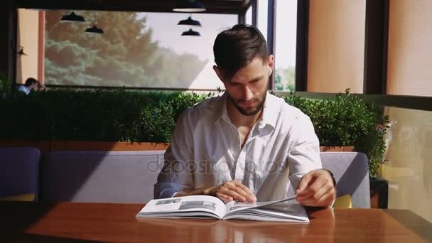 Graphic designer reading catalog at cafe. — Stock Video