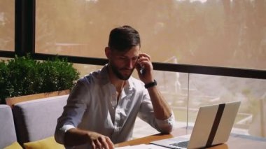Belgeleri okuma, masada dizüstü kullanarak ve smartphone ile arama müreffeh Satış Müdürü.