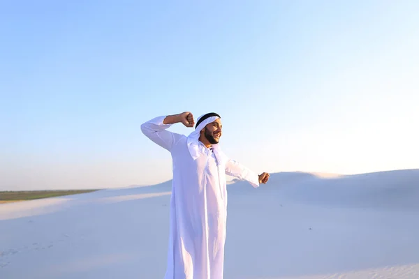 Cara muçulmano feliz caminha através de extensões de deserto e descansa com — Fotografia de Stock
