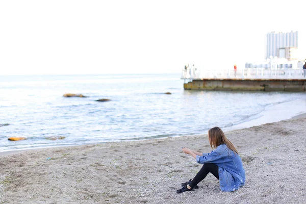 Красива молода жінка відпочиває сидячи на пляжі і насолоджується видом — стокове фото
