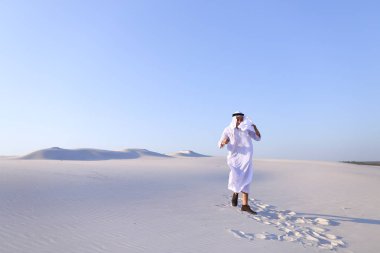 Mutlu Arap babası beyaz çöl ortasında yürüyor ve yaşam o sever