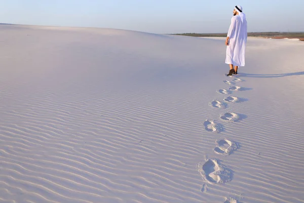 Радісний чоловічого мусульманської прогулянки по білому піску пустелі і користується Лі — стокове фото