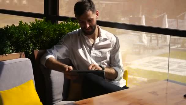 Ευρωπαϊκό επιχειρηματίας χρησιμοποιώντας tablet στο τραπέζι του καφέ. — Αρχείο Βίντεο
