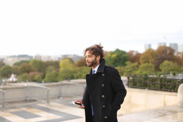 Novio árabe hablando en el teléfono inteligente cerca de la Torre Eifel en mot lento — Foto de Stock