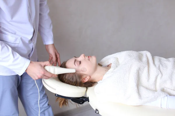 Cosmetologist guy makes special face massage to girl with cosmet — Stock Photo, Image