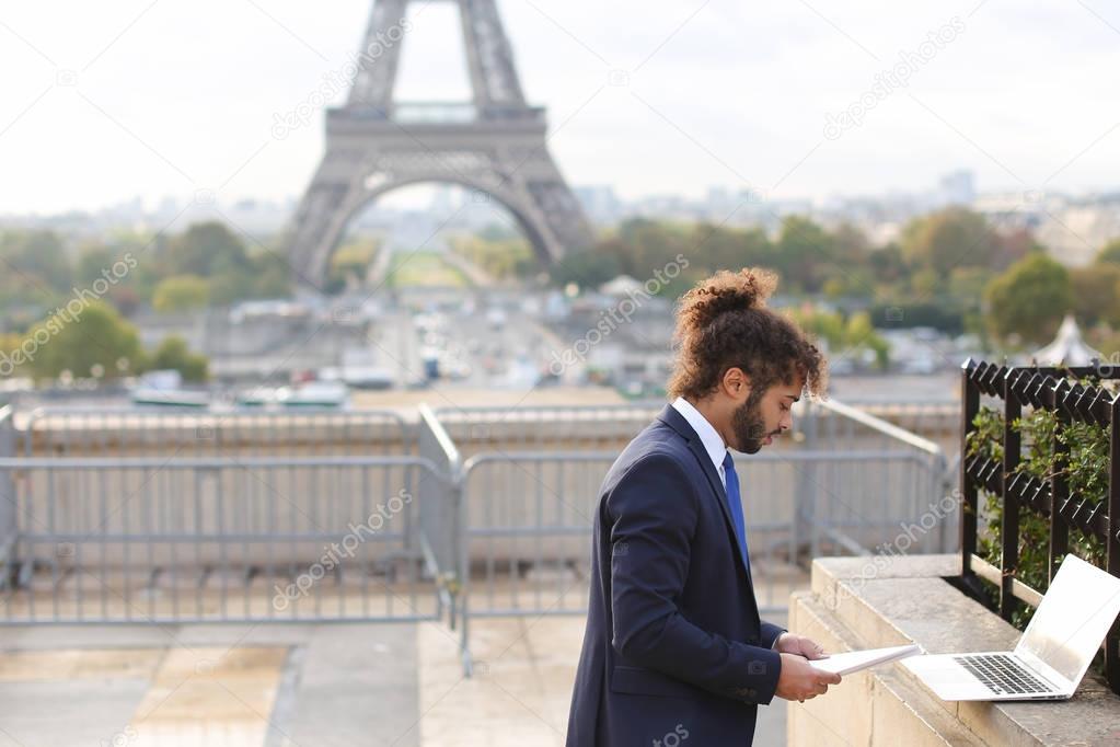 Travel manager using laptop with Eiffel Tower in background in s