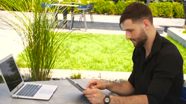 Freiberuflerin arbeitet mit Tablet und Laptop draußen. — Stockvideo