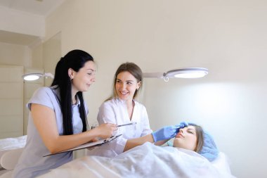 Kadın kaş dövme ana kız öğrenci c ile çalışmak için öğretir