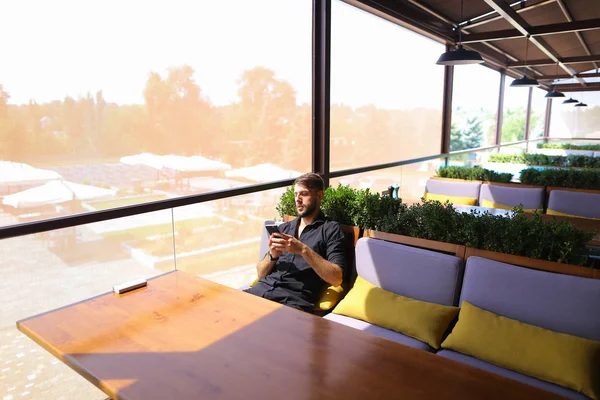 Hombre próspero utilizando el teléfono inteligente para la conversación un banco de energía un — Foto de Stock