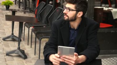 Ağır çekimde kafeterya masada tablet kullanarak online poker oyuncusu.