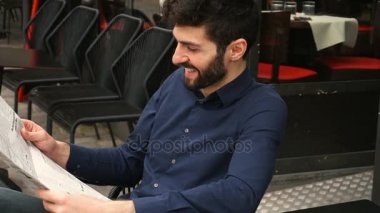 Gazeteci ile yakın çekim yüz gazete makalesi Cafe masa yavaş okuma.