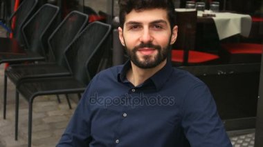 Erkek modeli ile kameraya bakarak ve ağır çekimde gülümseyen yüzünü kapat.