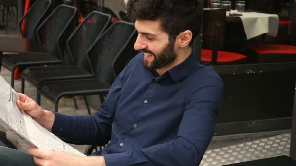 Periodista con cara cercana leyendo artículo de periódico en la mesa del café en cámara lenta . — Vídeo de stock