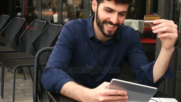 행복 한 사람이 쇼핑 카드와 슬로우 모션에 얼굴 가까이와 거리 카페에서 태블릿 온라인. — 비디오