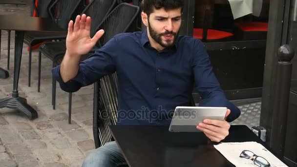 Ontevreden mens spelen online game door Tablet PC op straat café. — Stockvideo