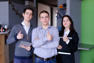 Üç kendine güvenen erkek ve kız öğrenci veya w ayağa çalışanlar