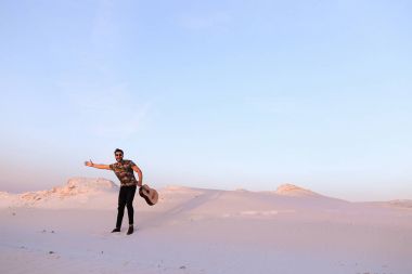 Arap adam çöl güzelliği ile ilham gider ve gitar çi çalış