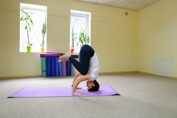 Bella giovane donna con i capelli scuri esegue esercizi di yoga . — Foto Stock