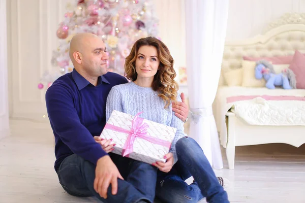 Enamorados jovens pais em troca de humor festivo Natal presen — Fotografia de Stock