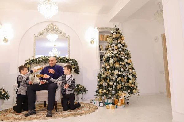 Vater und Kinder mit Zwillingsbuben tauschen Geschenke aus und lachen in l — Stockfoto