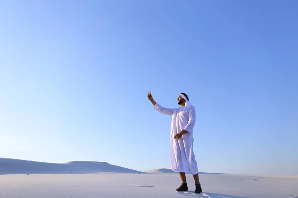 Cheerful Arab male tourist calls friend on Skype by cell and sho — Stock Photo, Image