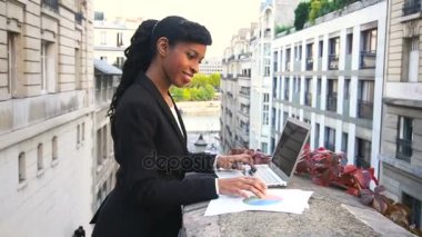 Yarım Afrika işkadını balkonda laptop ile çalışma.